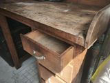 a wooden desk with a drawer and a tire on top of it