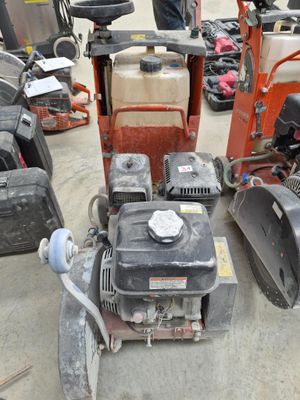 several lawn mowers are lined up in a lot with other lawn mowers in the background