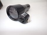 a black flashlight on a white table next to a cell phone