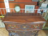 a wooden chest of drawers in a room with orange walls