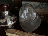 a piece of bread sitting on a table next to a glass vase