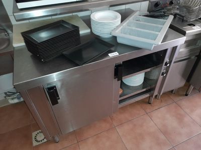 un plan de travail en acier inoxydable sur lequel sont posés de la vaisselle et des casseroles