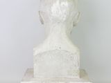 a white marble busturine of a man ' s head on a pedestal