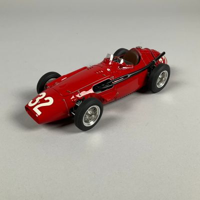 a red model of a racing car on a white surface