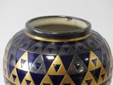 a blue and gold vase sitting on a white surface