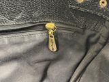 the zipper of a black purse with a gold zipper on it