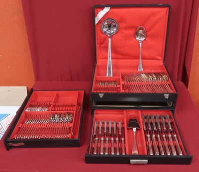 two trays of silverware on a red table