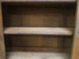 an old wooden cabinet with shelves and a door