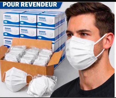 a man wearing a face mask next to a box of disposable face masks