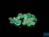 a close up of a bunch of green gems on a black surface