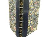 an old book with a blue cover and a floral design