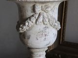 a white vase sitting on a table next to a mirror
