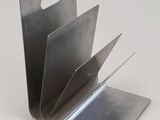 a close up of a metal book holder on a white surface