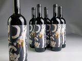 trois bouteilles de vin ornées d'un motif, posées sur une table