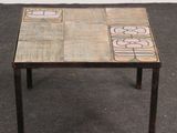 une petite table posée à même le sol, avec un plateau en carrelage