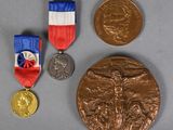 three medals and a medal on a table with a gray background