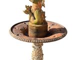 une statue d'oiseau sur un piédestal avec un oiseau dessus