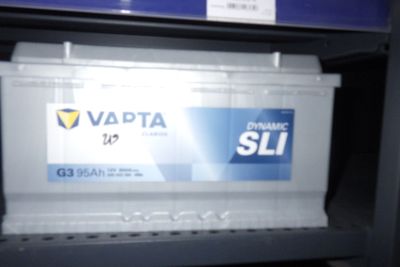 une photo d'une batterie de voiture posée sur une étagère dans un magasin