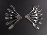 a lot of spoons and forks laid out on a table