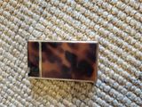 a picture of a tortoise shell business card holder on a carpet