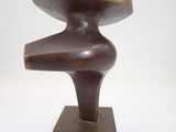 bronze sculpture of a mushroom on a wooden base on a white surface
