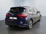 the back end of a blue nissan versa parked in a showroom