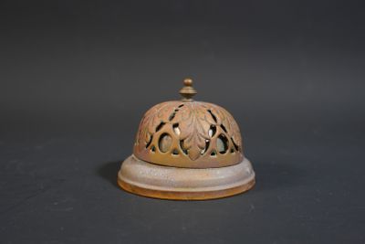 a small bell on top of a table on a black background
