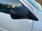 une camionnette blanche garée sur un parking à côté d'un bâtiment