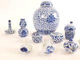 de nombreux vases bleus et blancs posés sur une surface blanche