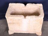 a stone planter sitting on a table with a blue background