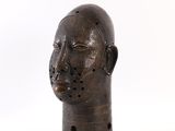 une sculpture en bois représentant une tête d'homme sur fond blanc