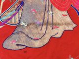 a red cloth with a picture of a woman riding a horse
