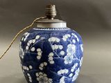 un vase bleu orné de fleurs blanches, posé sur une table