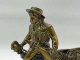 a bronze statue of a man on a boat with a dog