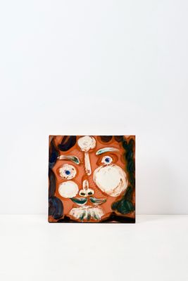 une photo d'un tableau représentant un visage posé sur une table