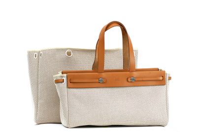 beige and white canvas tote bag with tan leather handles