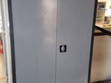 une armoire métallique dans un garage, avec un autocollant jaune sur la porte