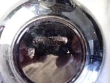 a close up of a metal object with a lizard on it