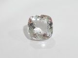 an uncutted cushion cut diamond on a white surface