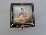 a small box with a painting on it on a table