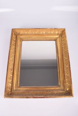 un miroir à cadre doré accroché à un mur blanc