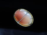 a picture of a ring with a coral stone in it