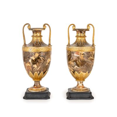 pair of antique bronze vases on marble bases on a white background