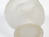 a glass vase with a face on it on a white surface