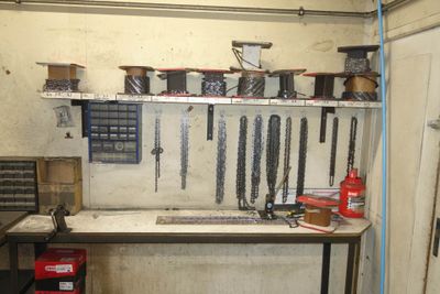 une photo d'un établi dans un garage, avec des outils accrochés au mur