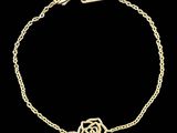 a gold plated bracelet with a flower on a chain