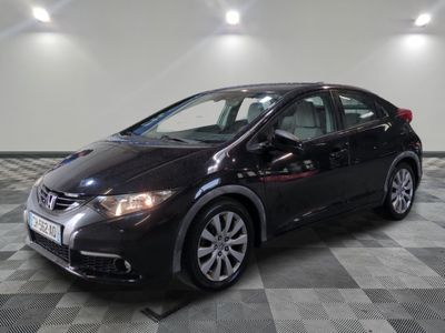 La Honda Civic noire est garée sur un sol en carrelage à damier.