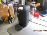 a coffee maker sitting on top of a table in a garage