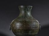 an old green vase sitting on top of a wooden stand