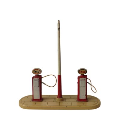 une station-service à l'ancienne avec deux pompes rouges et un mât blanc